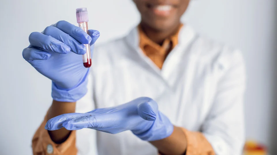 Lab technician holding blood test tube