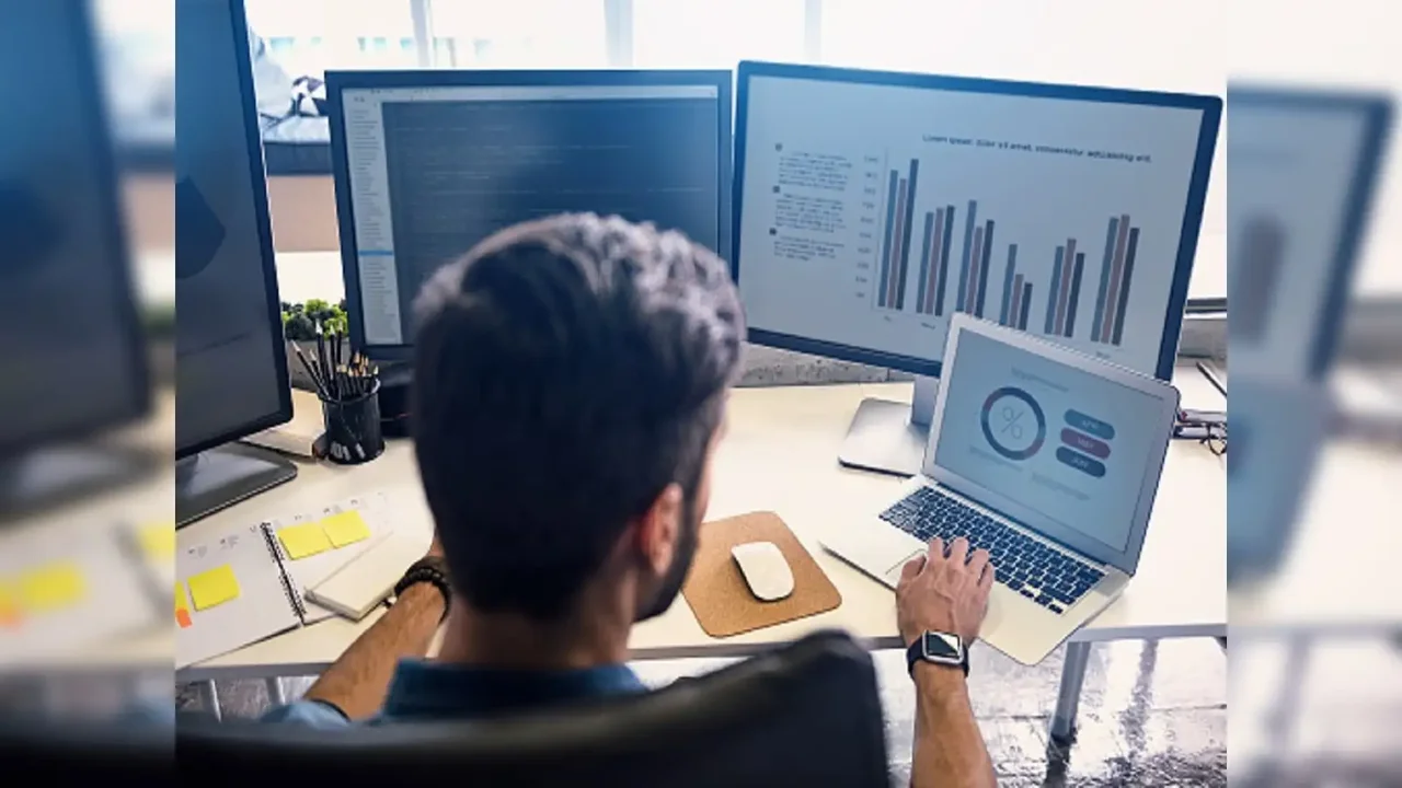 Man working on double monitors and laptop