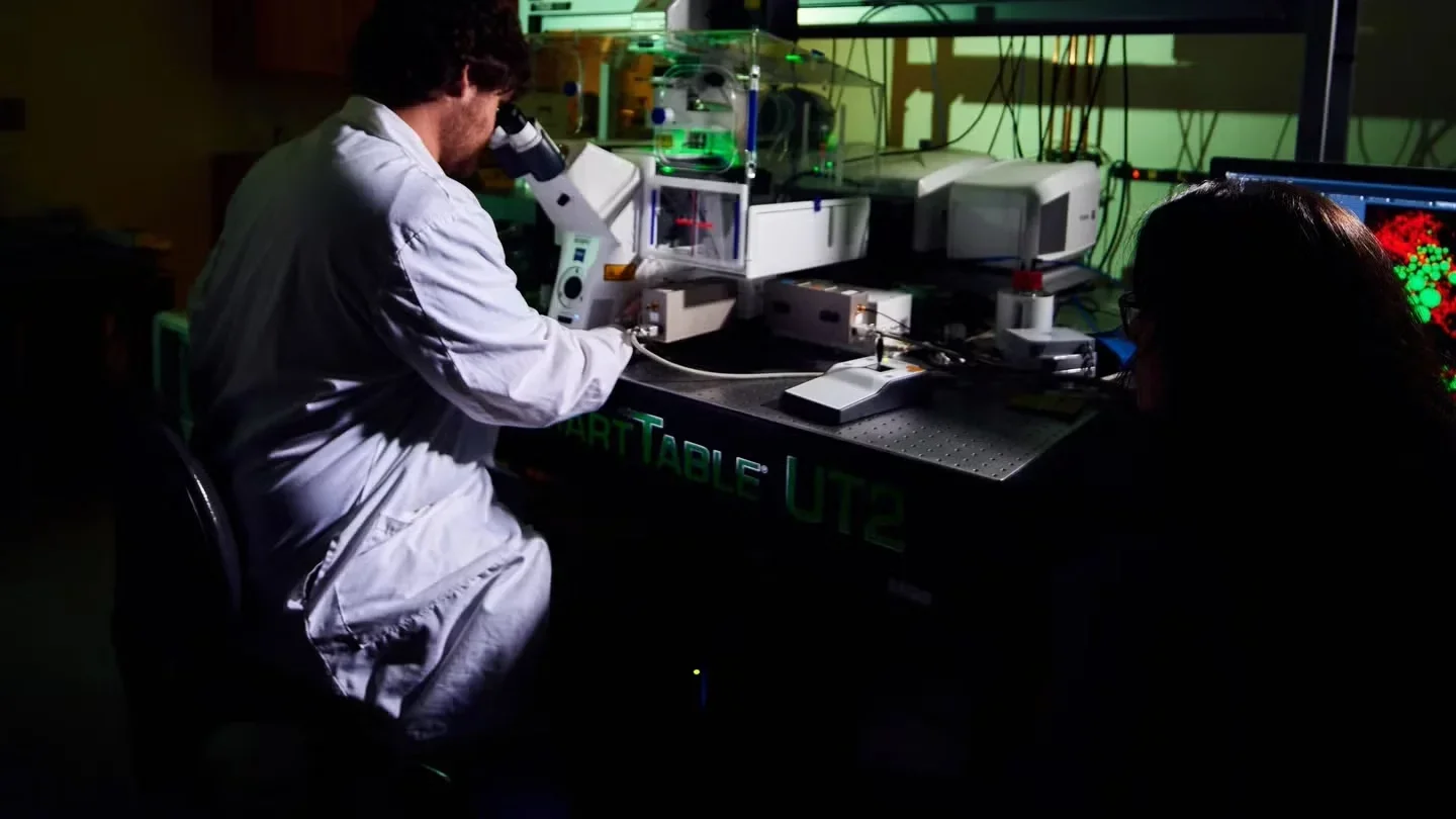 Researcher looking through microscope in lab