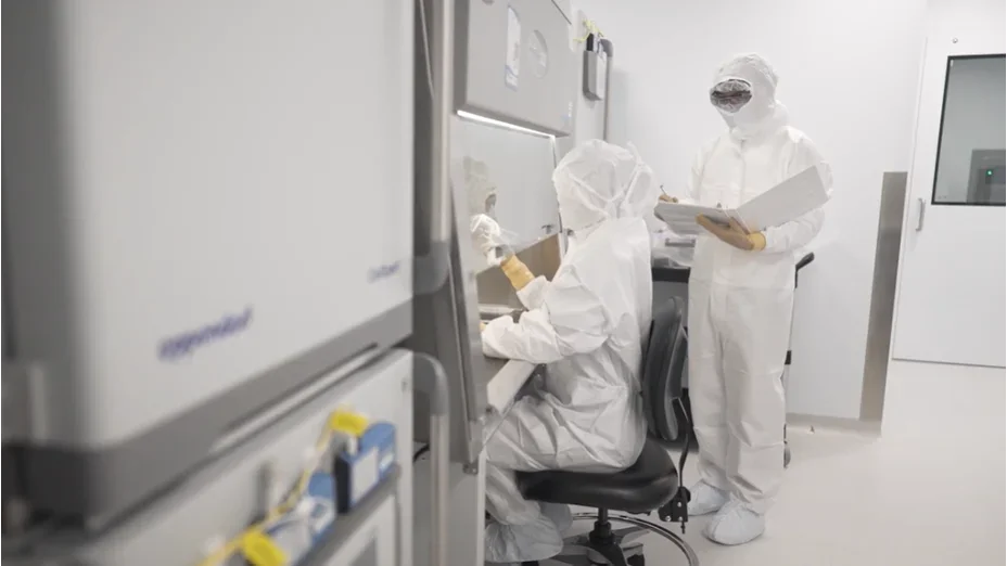 Researchers in PPE attire in lab