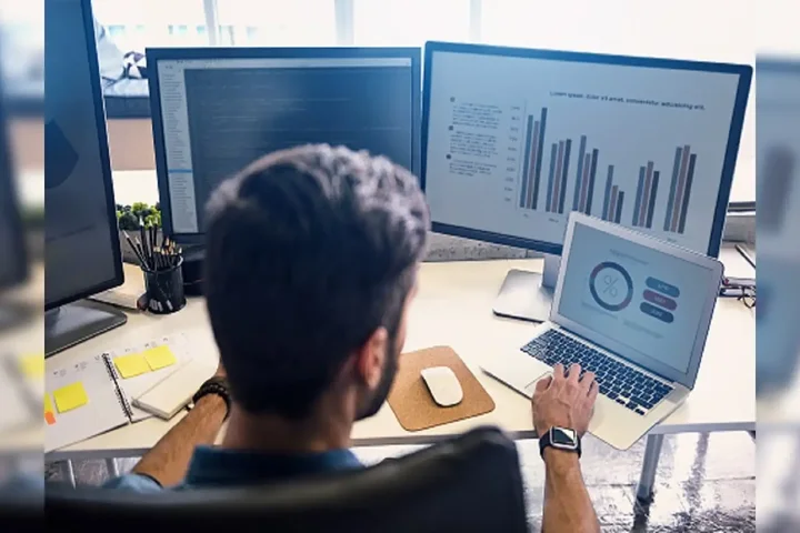 Man working on double monitors and laptop
