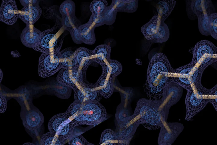 Protein structure with atomic model (yellow sticks) overlaid on a blue electron density map.