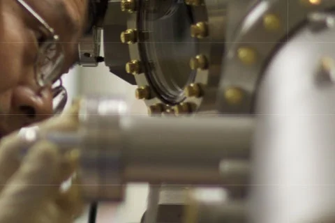 Close-up of a metallic scientific instrument with circular components and gold-colored bolts
