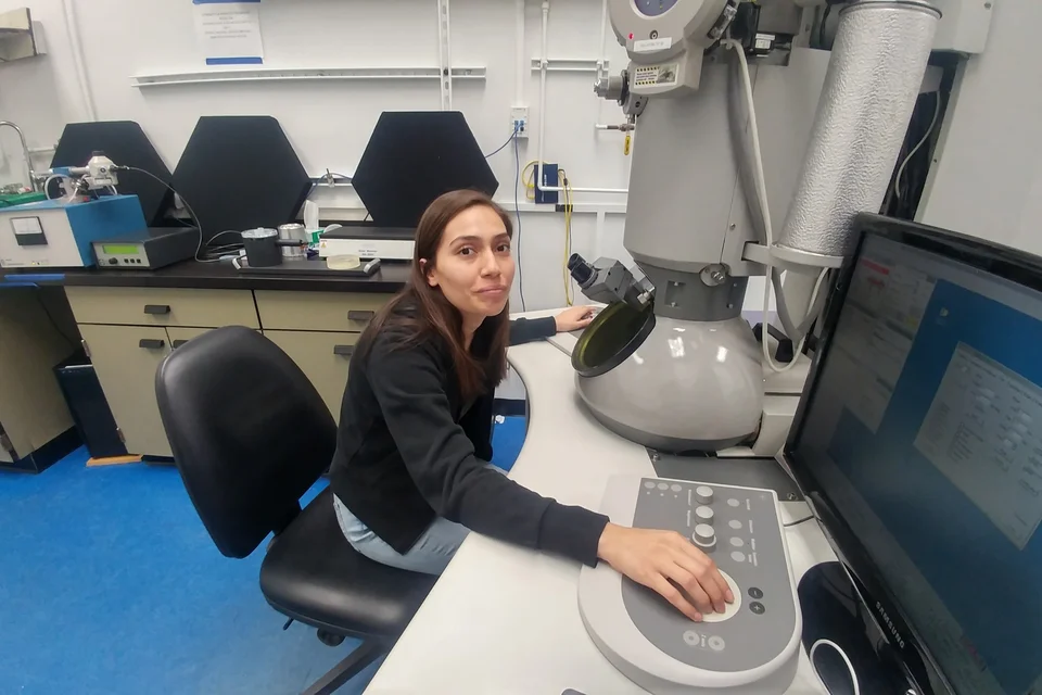 Maria Flores looking into a microscope