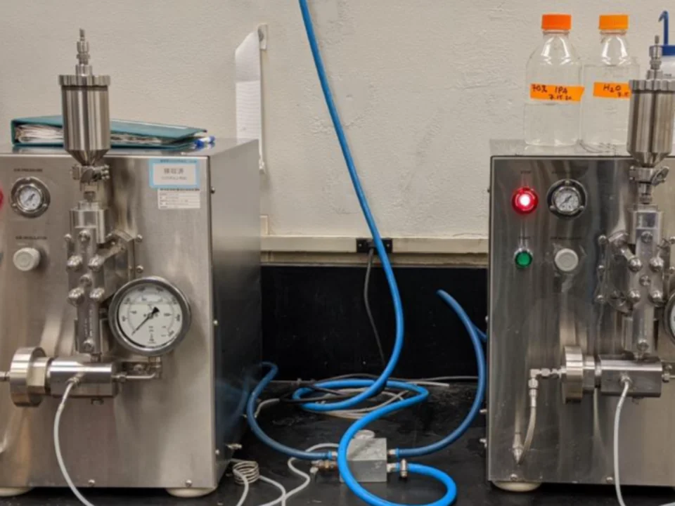 Laboratory-scale stainless steel bioreactor system with pressure gauge, tubing, and control panel.