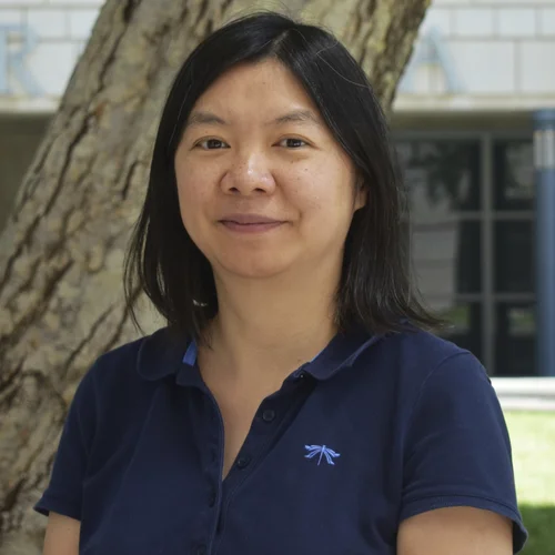 A professional headshot of Dr. Chunni Zhu in foreground, with tree in background
