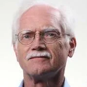 Side-by-side portrait of an older man with white hair, glasses, and a mustache, and a smiling woman with long blonde hair and black glasses.
