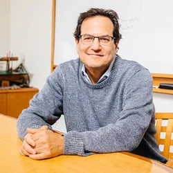 A portrait of Nelson Freimer, MD sitting behind a wooden table. 